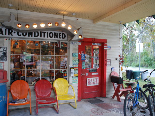 A vintage gas station serves as the entrance and gift shop for this roadside attraction-style labyrinth of buildings connected by walkways.